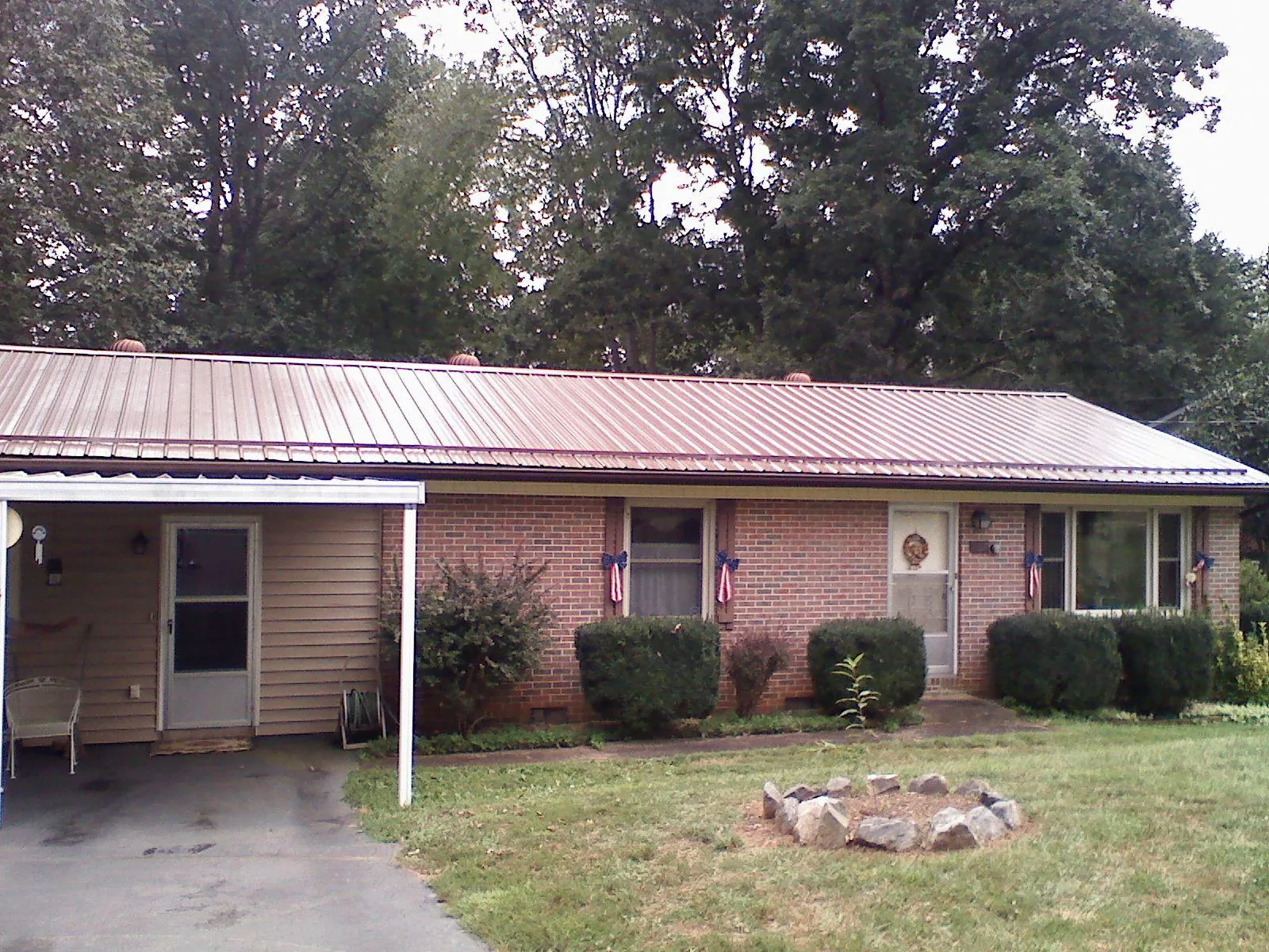 Bronze metal roof and carport on a brick ranch home — Roof Repair work by our crew in Glenford