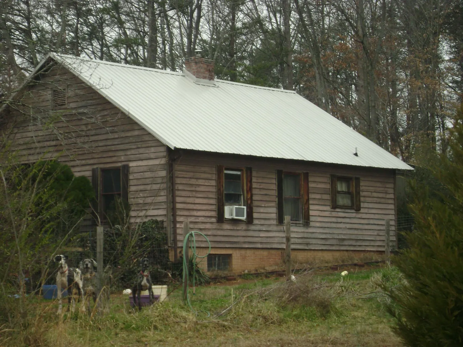 White metal roof on an old wood sided farmhouse, from a Metal Roof Installation job in Glenford